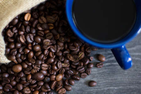 A cup of coffee on coffee beansの写真素材