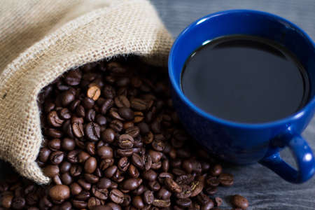 A cup of coffee on coffee beansの写真素材