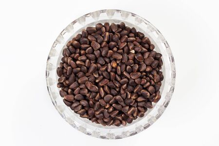 pine nuts in a cup on a white backgroundの写真素材