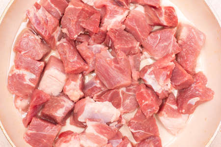 A piece of raw pork meat in a frying panの写真素材