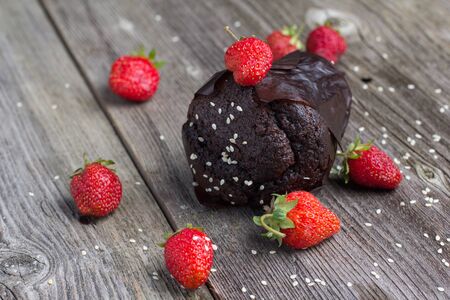 Fresh chocolate muffin with berries on the rustic table for breakfastの写真素材