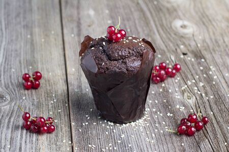 Fresh chocolate muffin with berries on the rustic table for breakfastの写真素材