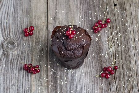Fresh chocolate muffin with berries on the rustic table for breakfastの写真素材