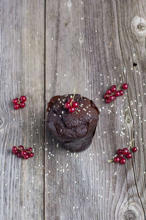 Fresh chocolate muffin with berries on the rustic table for breakfastの写真素材
