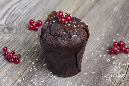 Fresh chocolate muffin with berries on the rustic table for breakfastの写真素材