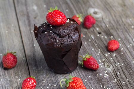 Fresh chocolate muffin with berries on the rustic table for breakfastの写真素材