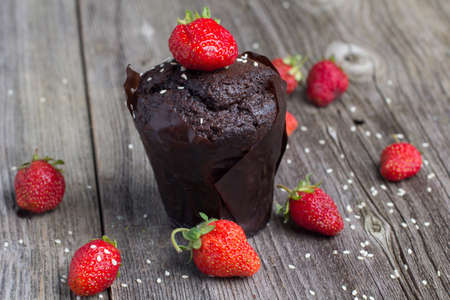 Fresh chocolate muffin with berries on the rustic table for breakfastの写真素材