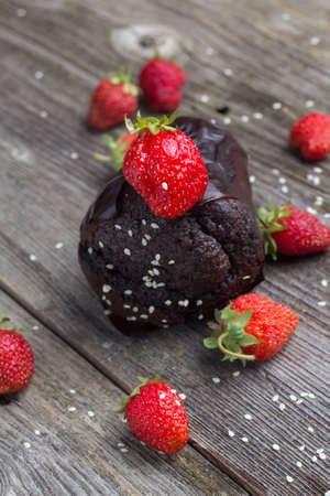 Fresh chocolate muffin with berries on the rustic table for breakfastの写真素材