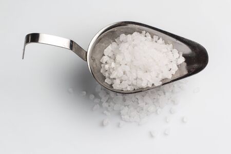 Sea salt in an iron bowl on a white backgroundの写真素材