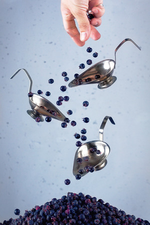 Still life - pouring berries irgi between iron cupsの写真素材