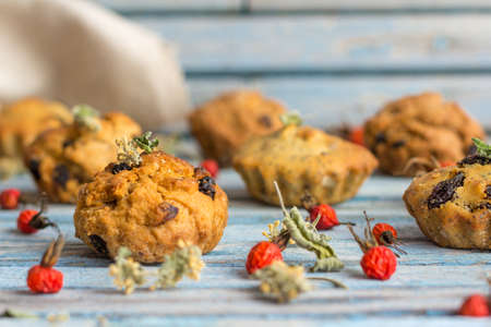 Fresh homemade delicious carrot muffins with raisins and dried fruits on a wooden backgroundの写真素材