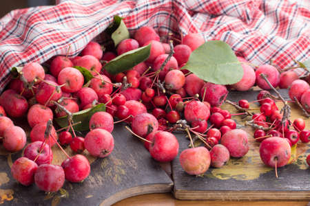 Red apples and leaves on a wooden tableの写真素材