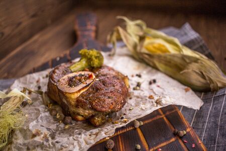 Baked lamb knee and close-up on a wooden boardの写真素材