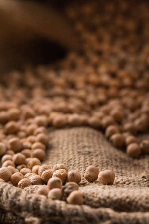Placer chickpea in burlap on a wooden backgroundの写真素材
