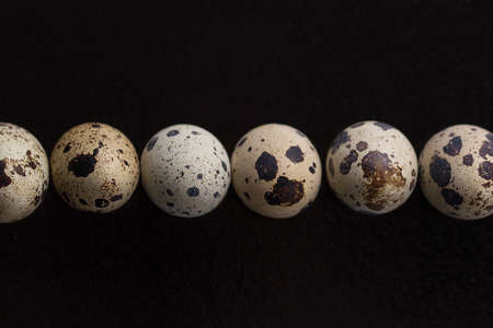 Quail eggs on a black background. Many quail eggs.の写真素材
