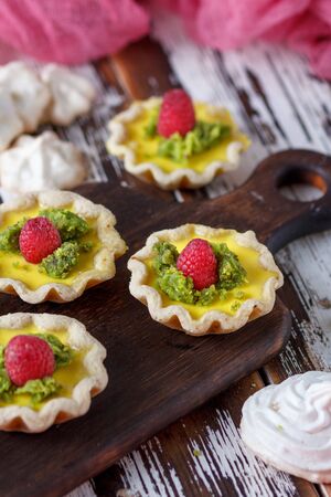 Still life - Delicious homemade lemon tart. Pie on rustic white table. Tart with raspberries and meringueの写真素材
