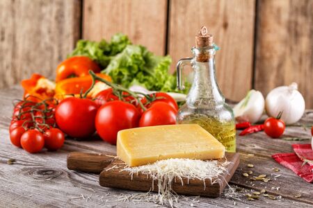 Still life with Parmesan cheese and fresh vegetables. In the Italian rustic style. Fresh vegetables with cheeseの写真素材