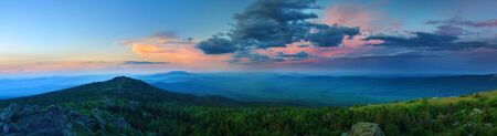 Sunset over the mountainous terrain. The nature of the Southern Urals. Sunset sky over the forest and the mountains. Panoramic viewの写真素材