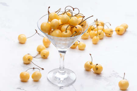 Yellow cherry in a cocktail glass on a white background. Fresh berries.の写真素材