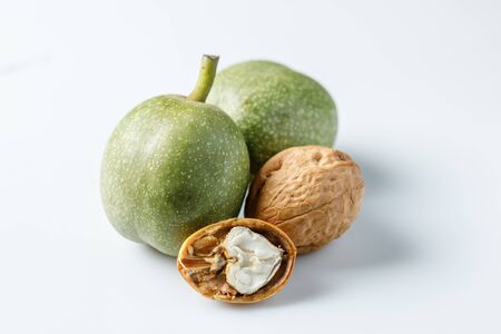 Fresh green walnuts in the skin just from the tree. Walnuts on a white background. Macro. Walnuts on...