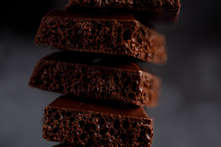 Porous chocolate in stack on a black background closeup. A slide of porous chocolate on a dark background.の写真素材