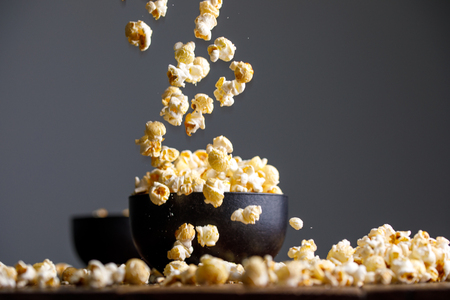 Levitating popcorn around a ceramic bowl. Appetizing still life.の写真素材
