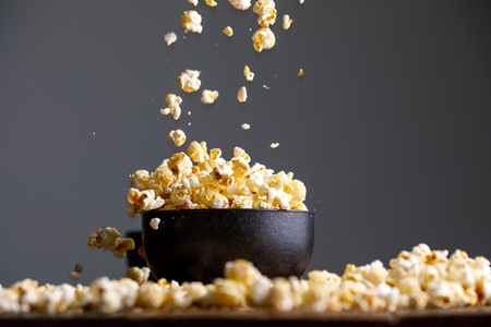 Levitating popcorn around a ceramic cup. Appetizing still life.の写真素材
