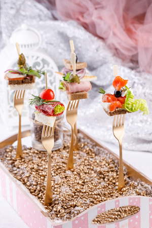 Original canapes on forks. Exquisite still life. Close-up.の写真素材