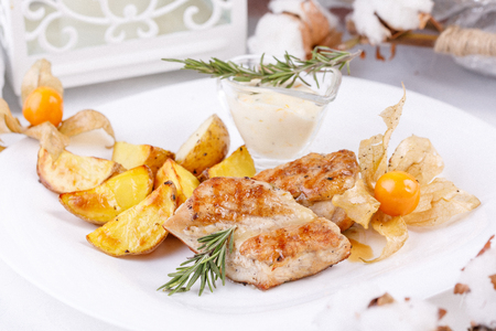 Delicate chicken fillet with a garnish of young potatoes. Close-up.の写真素材