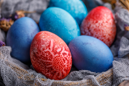 Eggs of unusual color in a wicker basket. Easter still life.の写真素材