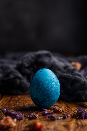 One egg, painted in a gently blue, on a wooden background. Easter still life.の写真素材
