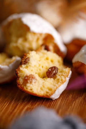 Fresh cracked cake with raisins in white glaze. Still-life on a wooden background.の写真素材
