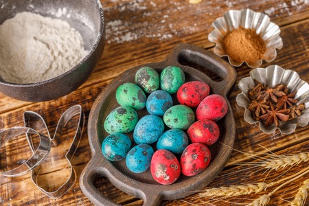 Still life on a wooden background. Painted in different colors quail eggs.の写真素材