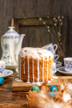 Beautiful tea set and Easter cake on a wooden background. Easter greeting card. Tea in the village for Easter. Home Easter cake and painted eggs for the holiday.の写真素材