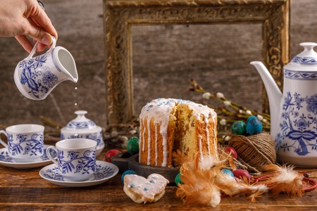 Fresh homemade cake in sugar icing for the holiday. Easter decorations on the table. Easter tea,...