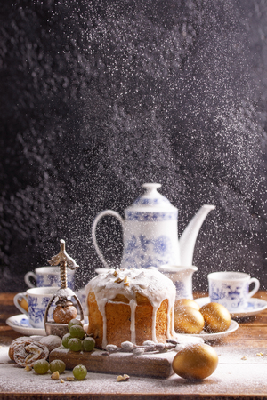 A beautiful vintage coffee set and antique nutcracker on a table decorated for Easter. Delicious, fresh homemade cake and traditional eggs, decorated for the holiday.の写真素材