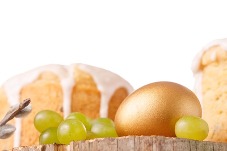 Traditional Russian Easter cakes kulich, with colored golden egg on a wooden background. Close-up.
