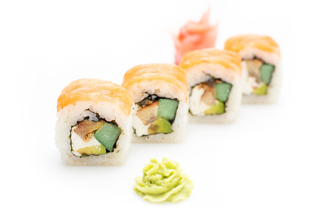 Appetizing sushi rolls with avocado, cucumber, eel and Philadelphia cheese wrapped in salmon. Isolated. Sushi roll on a white background. Sushi Japanese cuisine in the restaurant. Close-up. Japanese restaurant menu.の写真素材