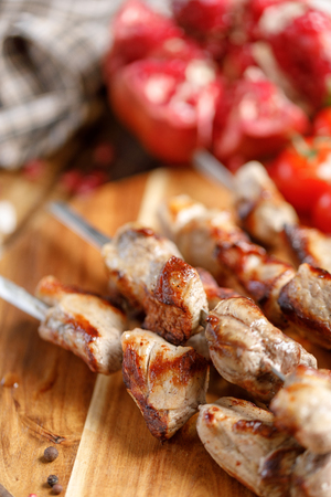 Shish kebabs from pork on skewers close-up. Juicy appetizing meat cooked on an open fire. Rustic. Still-life on a wooden background.の写真素材