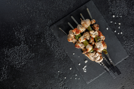 Juicy kebabs on skewers. Still life on a black background. Appetizing meat. View from above.の写真素材