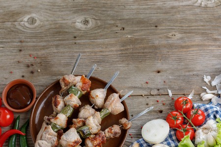 Juicy kebabs of pork and fresh vegetables. Still life on a wooden background. Rustic. Place under your text.の写真素材