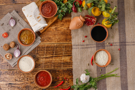 A set of sauces and condiments in ceramic cups top view. Place under your text.の写真素材