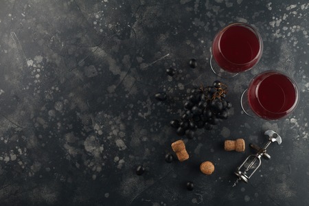 Wine top view background. Red wine in glass goblets with a corkscrew. On a black board.Top view with space for text.の写真素材