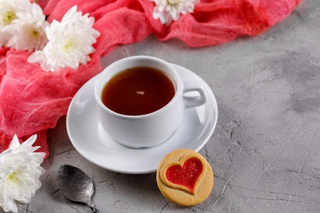 Cup of tea and cookies with hearts on a gray background. Beautiful still life with a cup of tea, the mood of Valentine's Day. Close-up.の写真素材