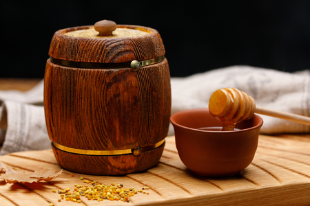 Wooden barrel with honey and a spoon on a wooden table. Barrel Rustic still life.の写真素材
