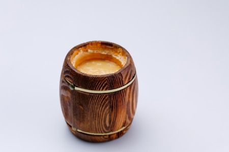 Wooden open barrel with honey on a white background. Close-up. Isolated.