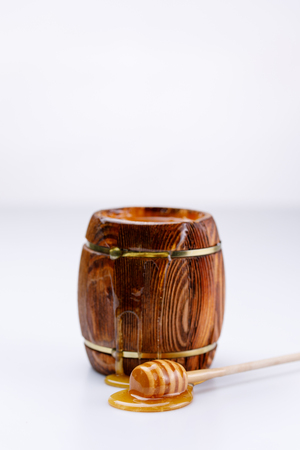 Fragrant fresh honey flowing from the barrel and honey stick on a white background. Isolated.の写真素材