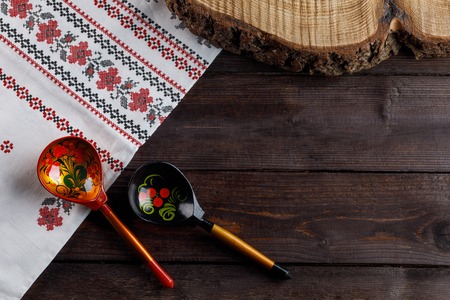 Wooden spoons with floral ornament in traditional folk Russian Khokhloma style on wooden table with...