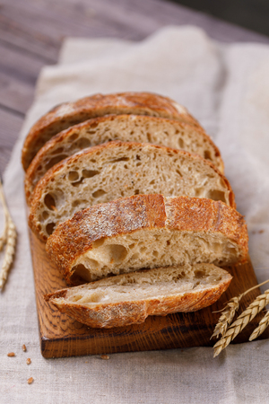 Sliced homemade rye bread on a board close-up. The concept of healthy food and traditional bakery. Rustic.の写真素材