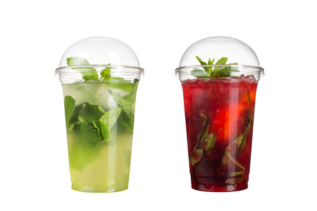 Delicious fruit smoothies in plastic cups, on a white background. Two cocktails with a taste of mojito and berry mojito. Isolatedの写真素材